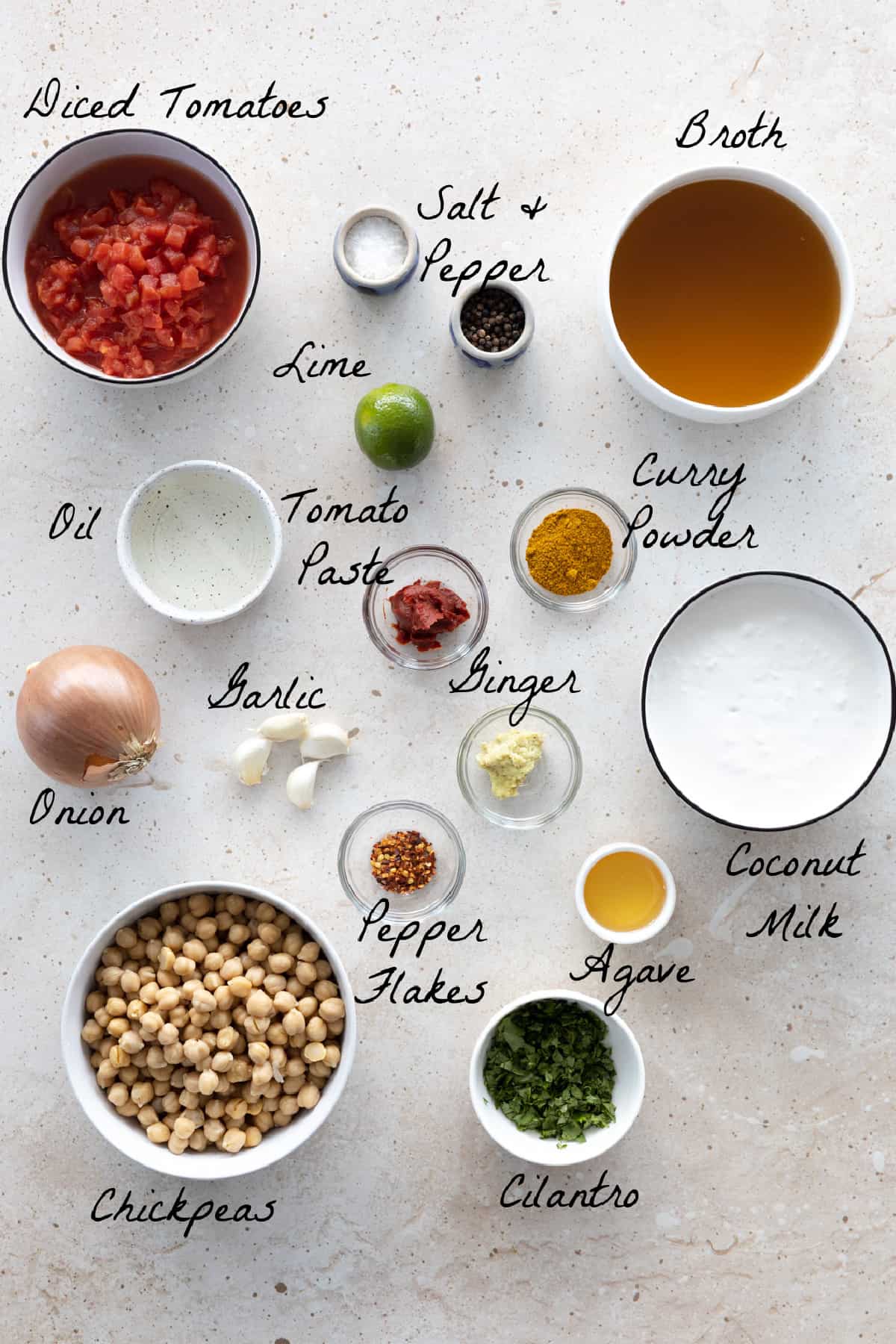 ingredients to make chickpea curry soup on a stone table top. 