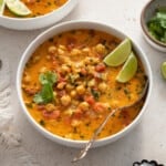 bowl of chickpea curry soup with a spoon inside.