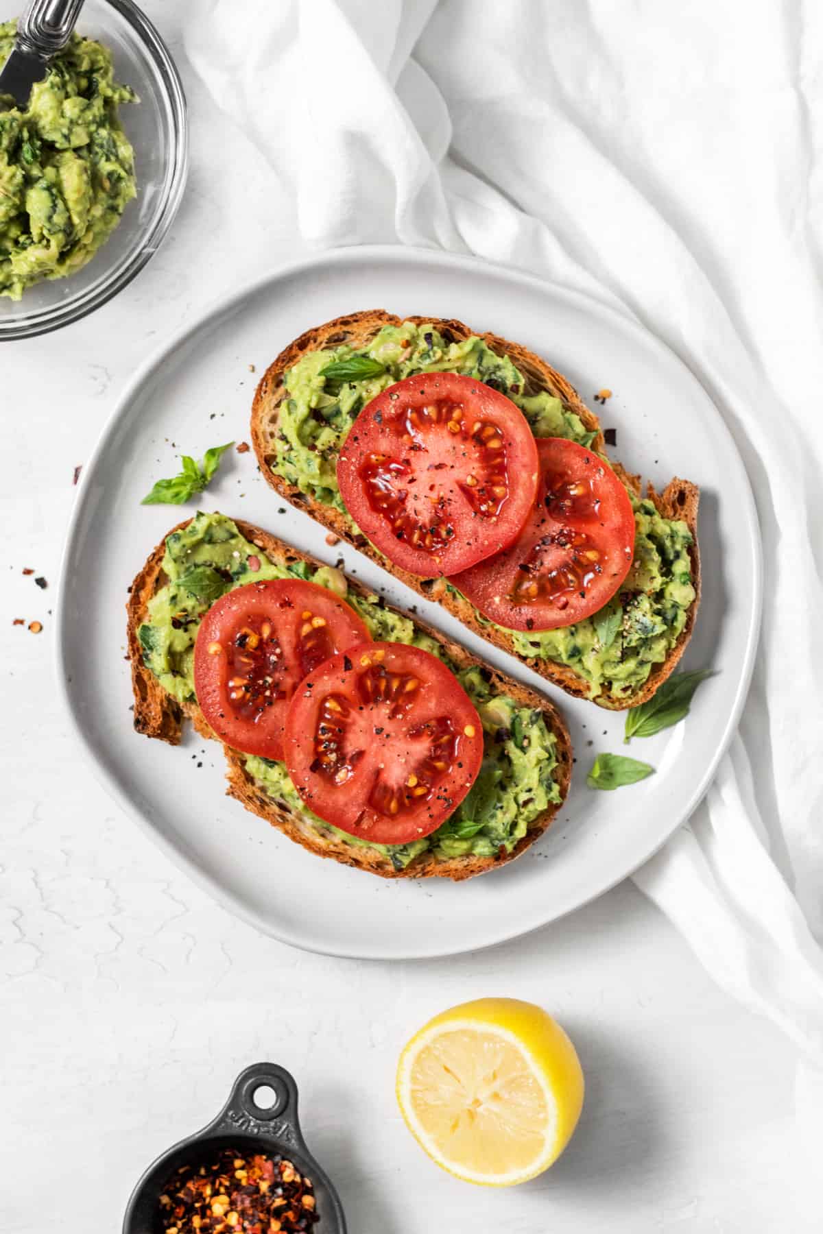 Overhead view of two slices of white bean avocado toast on a plate. 
