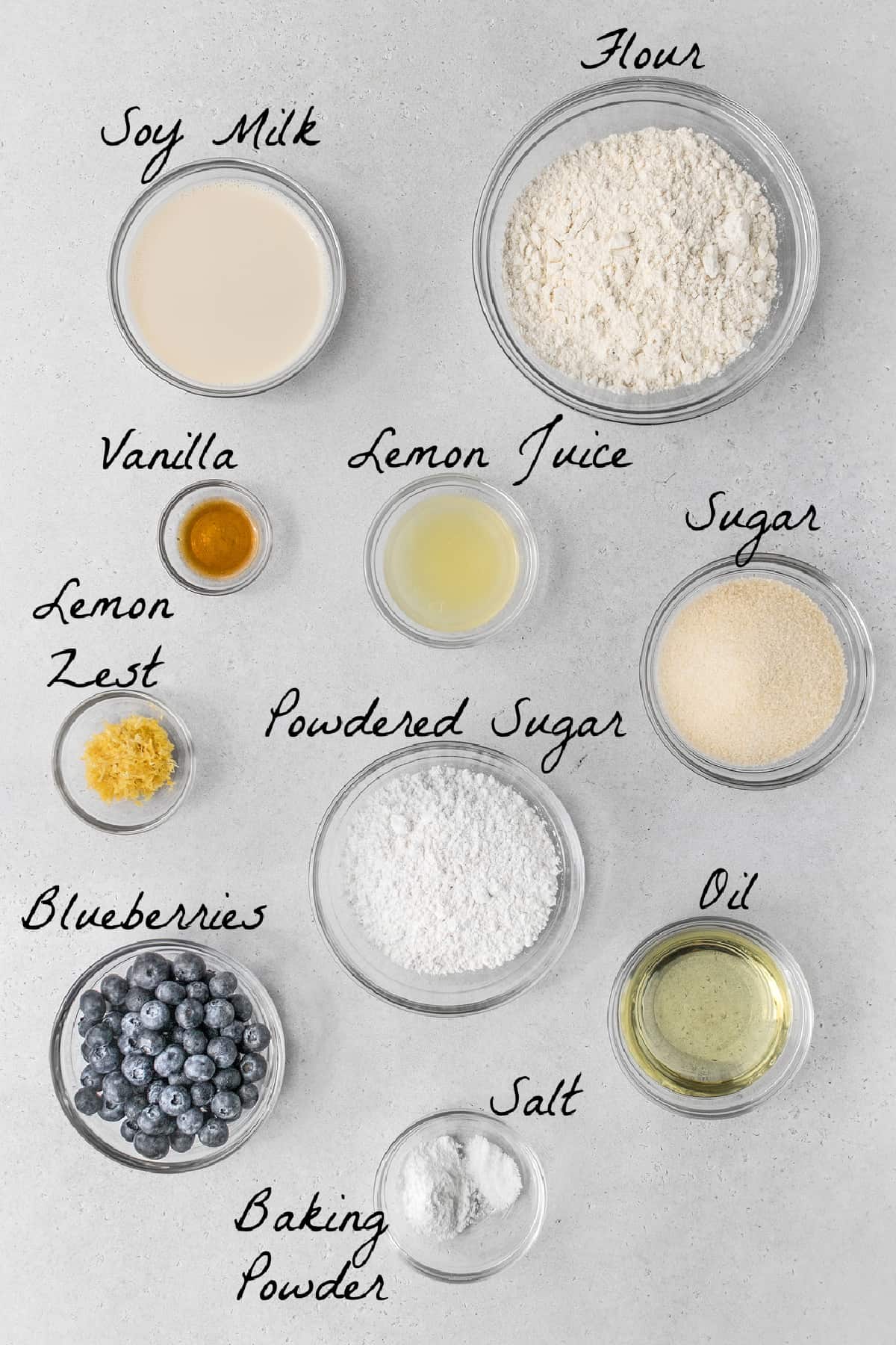 Ingredients to make lemon blueberry bread on a stone table top. 