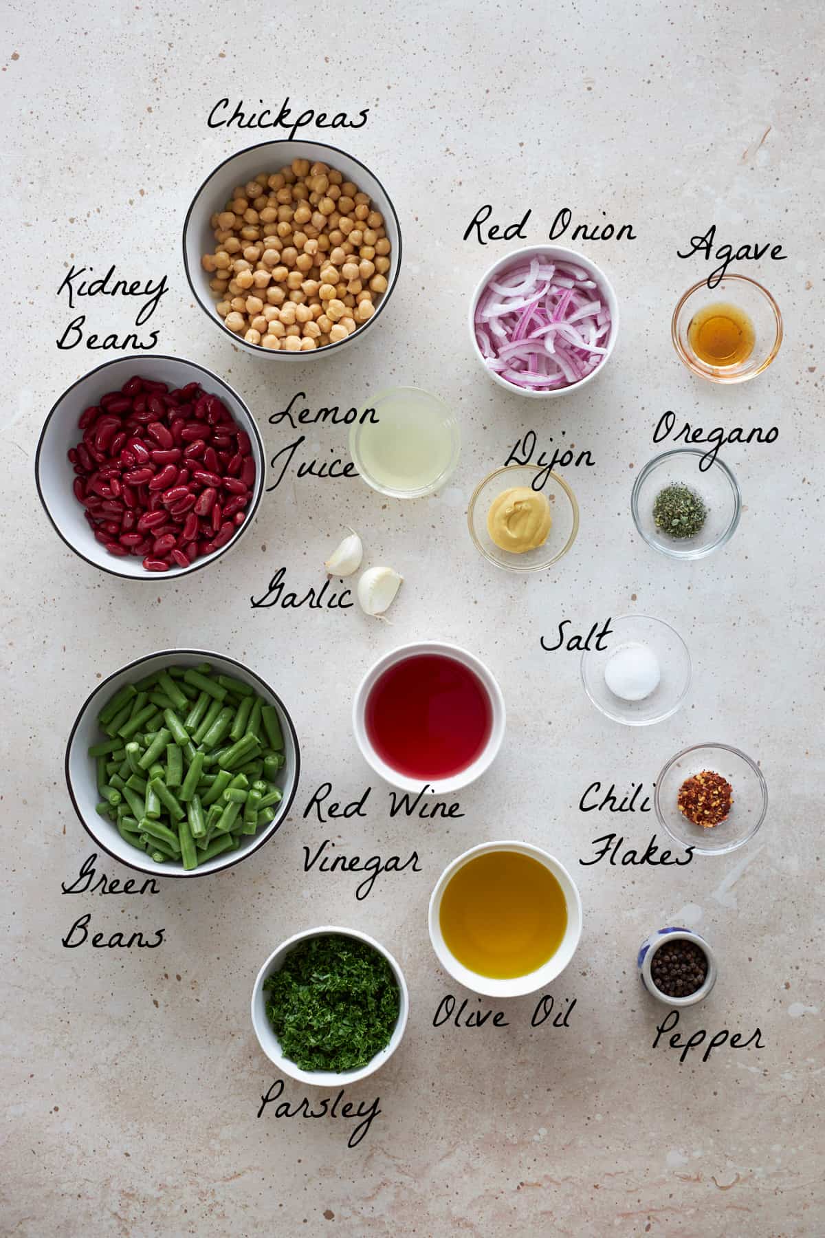 Ingredients to make bean salad placed on a stone tabletop .