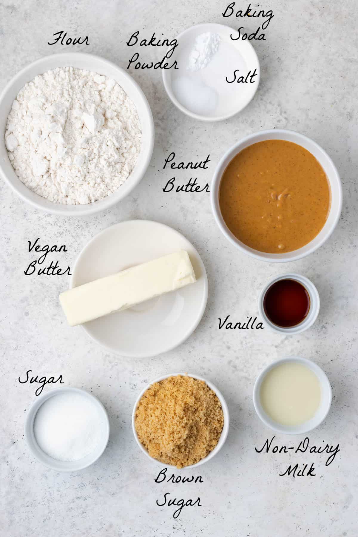Ingredients to make peanut butter cookies on a stone table top. 