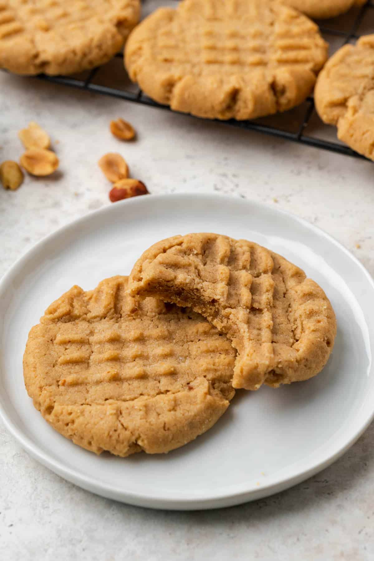 2 vegan peanut butter cookies on white plate. 