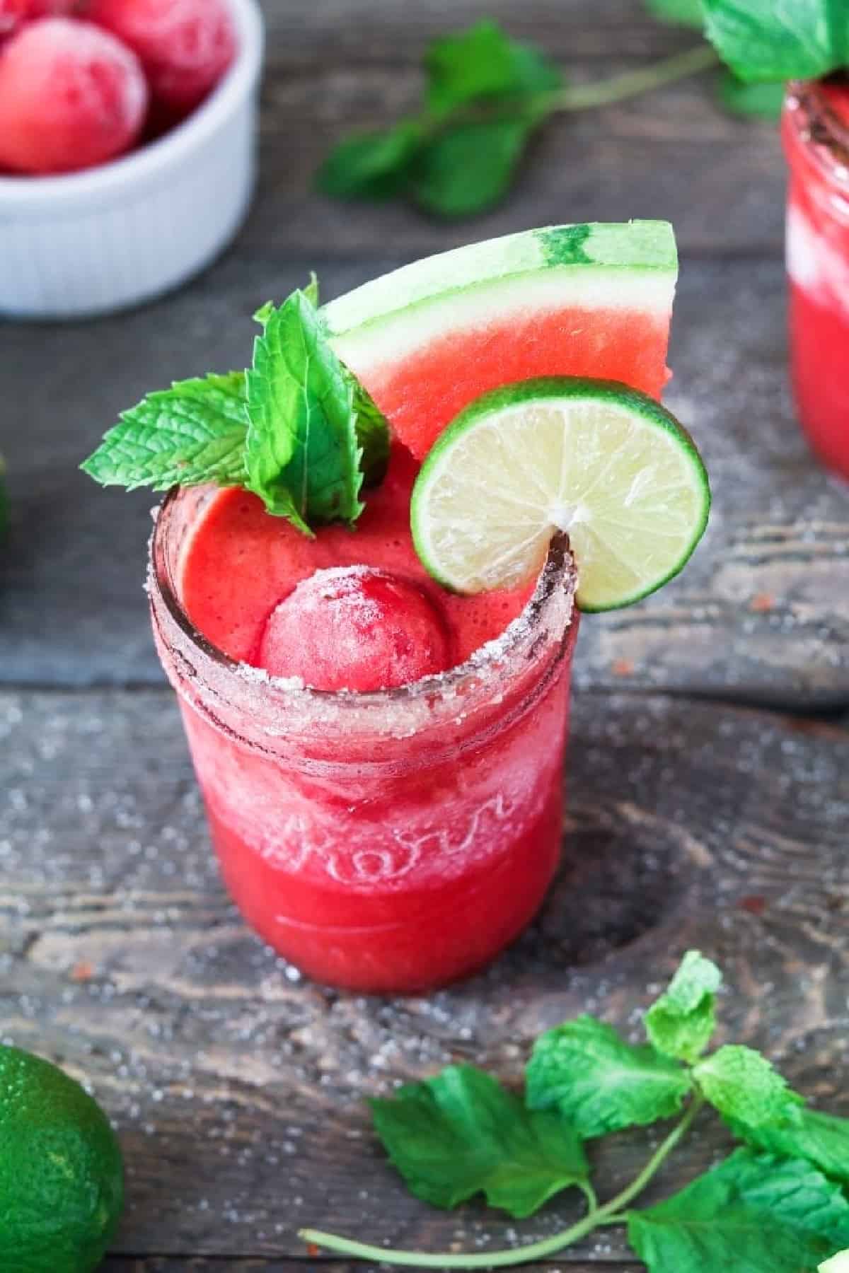 overhead view of a frozen watermelon margarita on a wood table. 