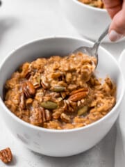 pumpkin spice oatmeal in a bowl with a spoon inside.