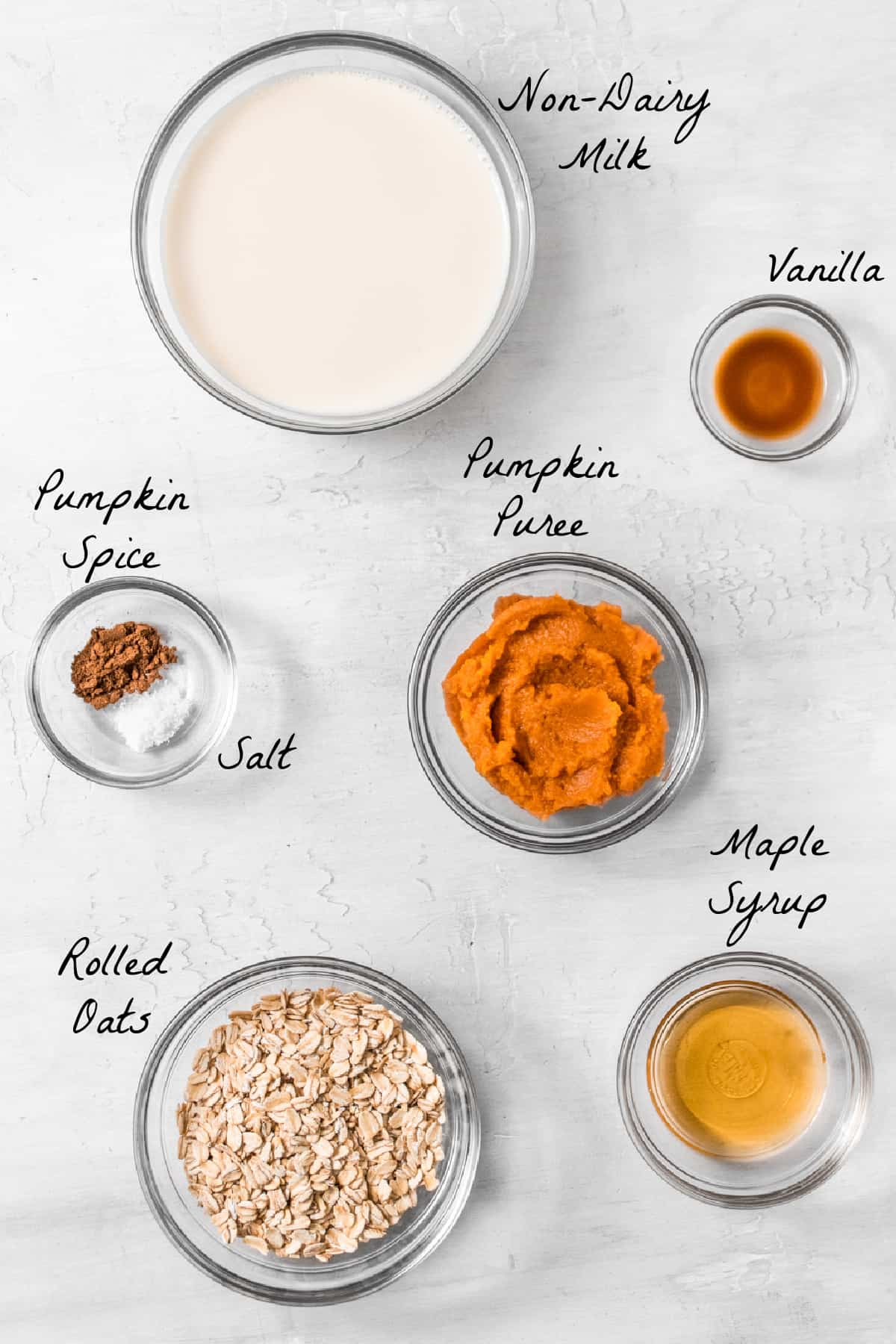 Ingredients to make the pumpkin oatmeal displayed on a stone table top. 