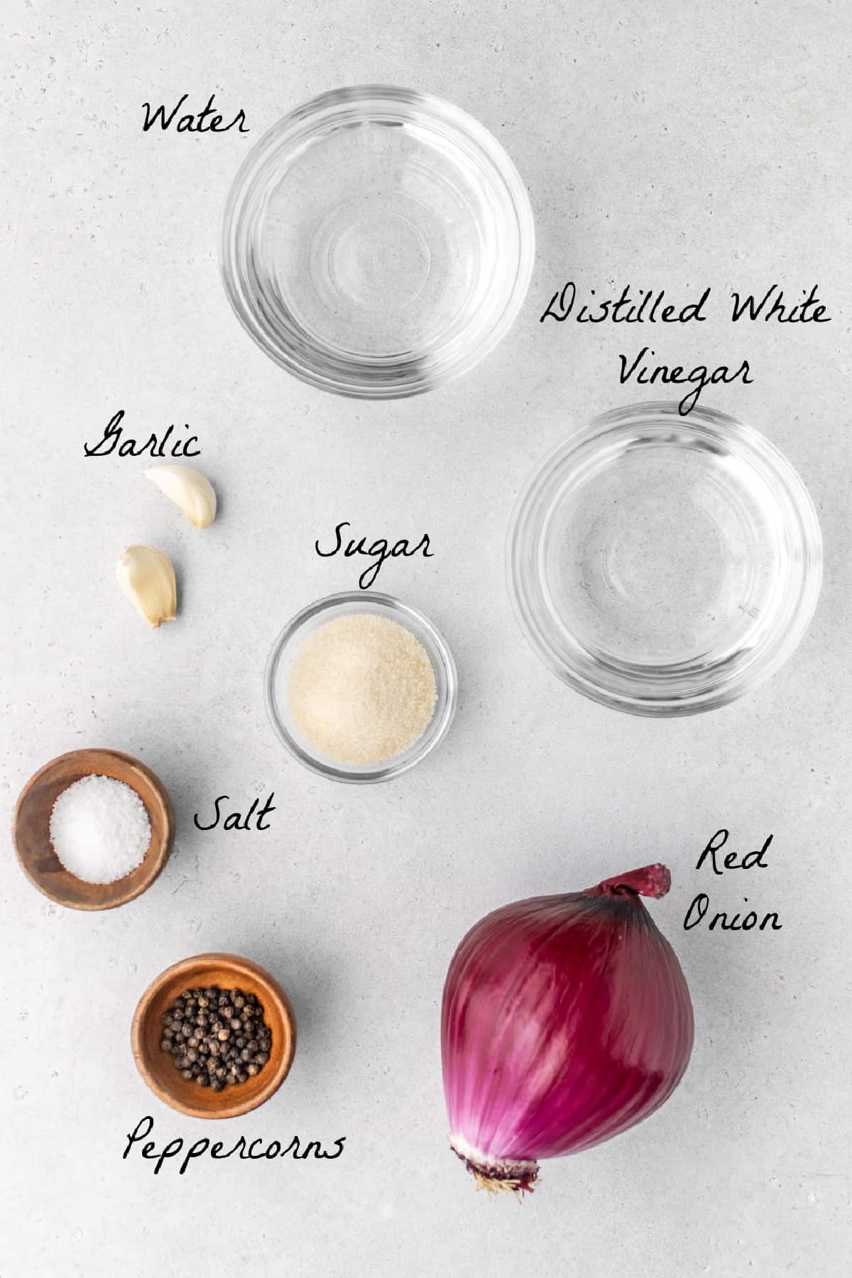 Ingredients to make pickled red onions on a stone table top. 