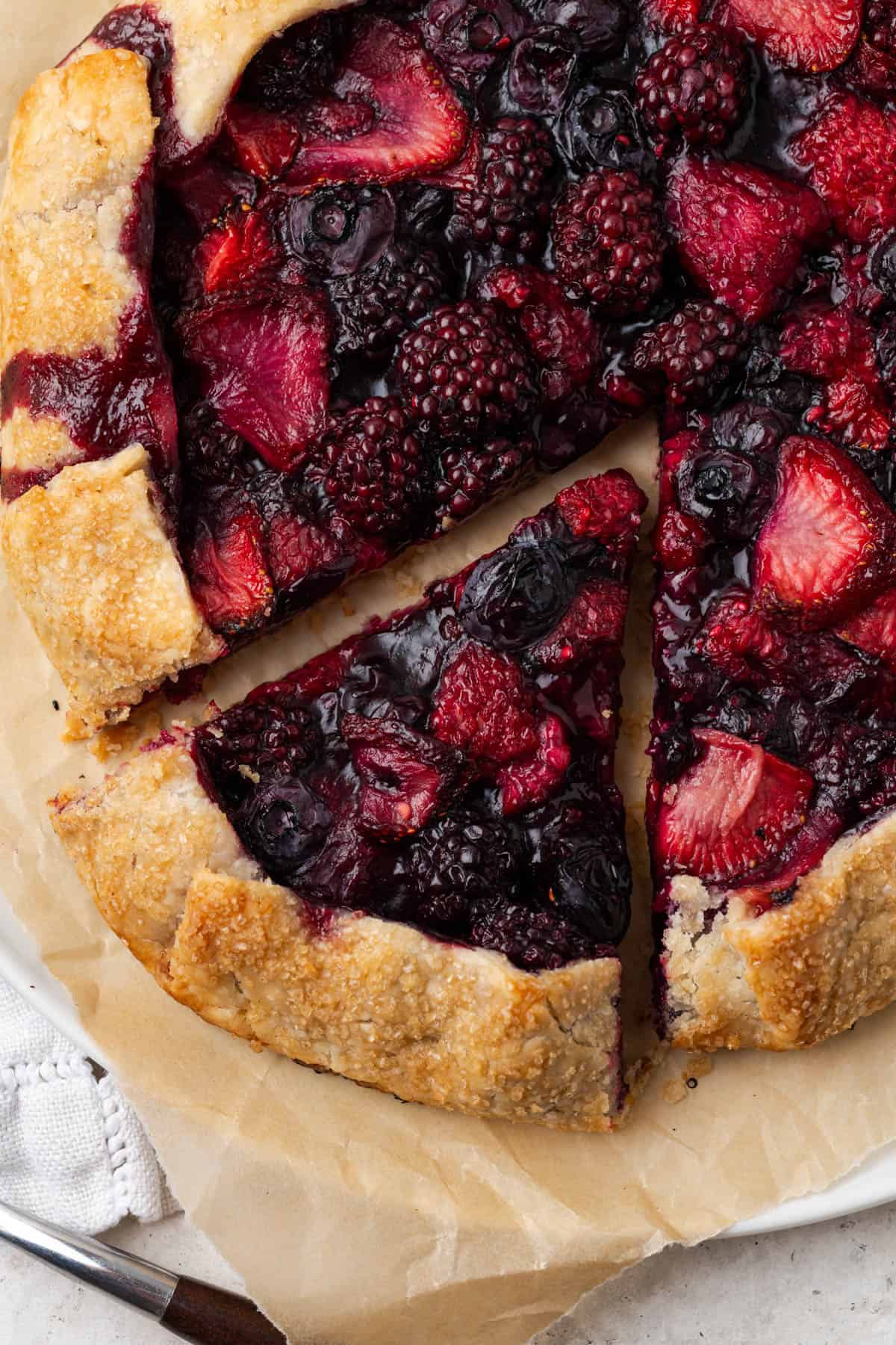 Closeup view of a fully baked berry galette on top of parchment paper.