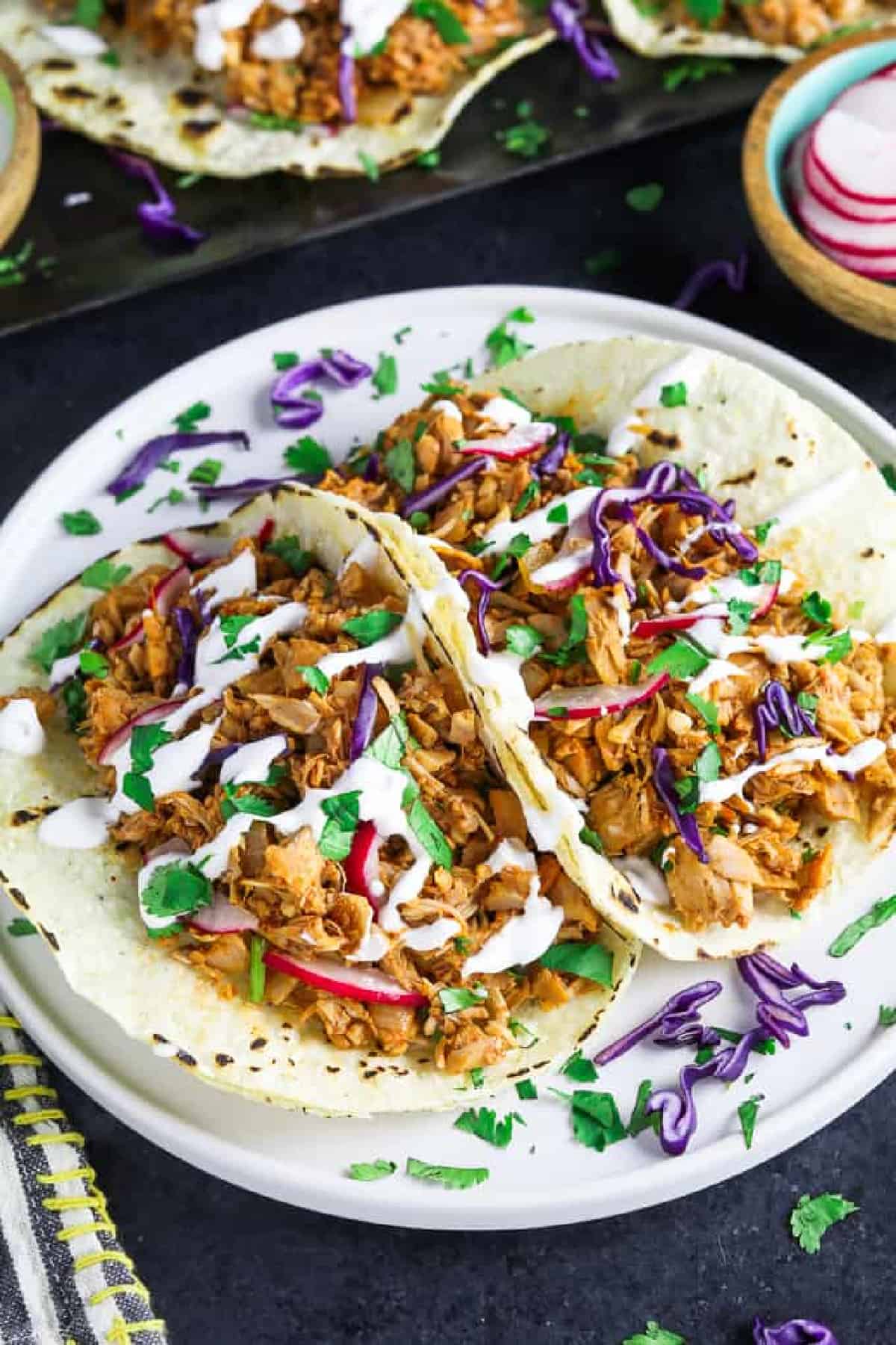 overhead view of two jackfruit tacos fully assembled on a plate.