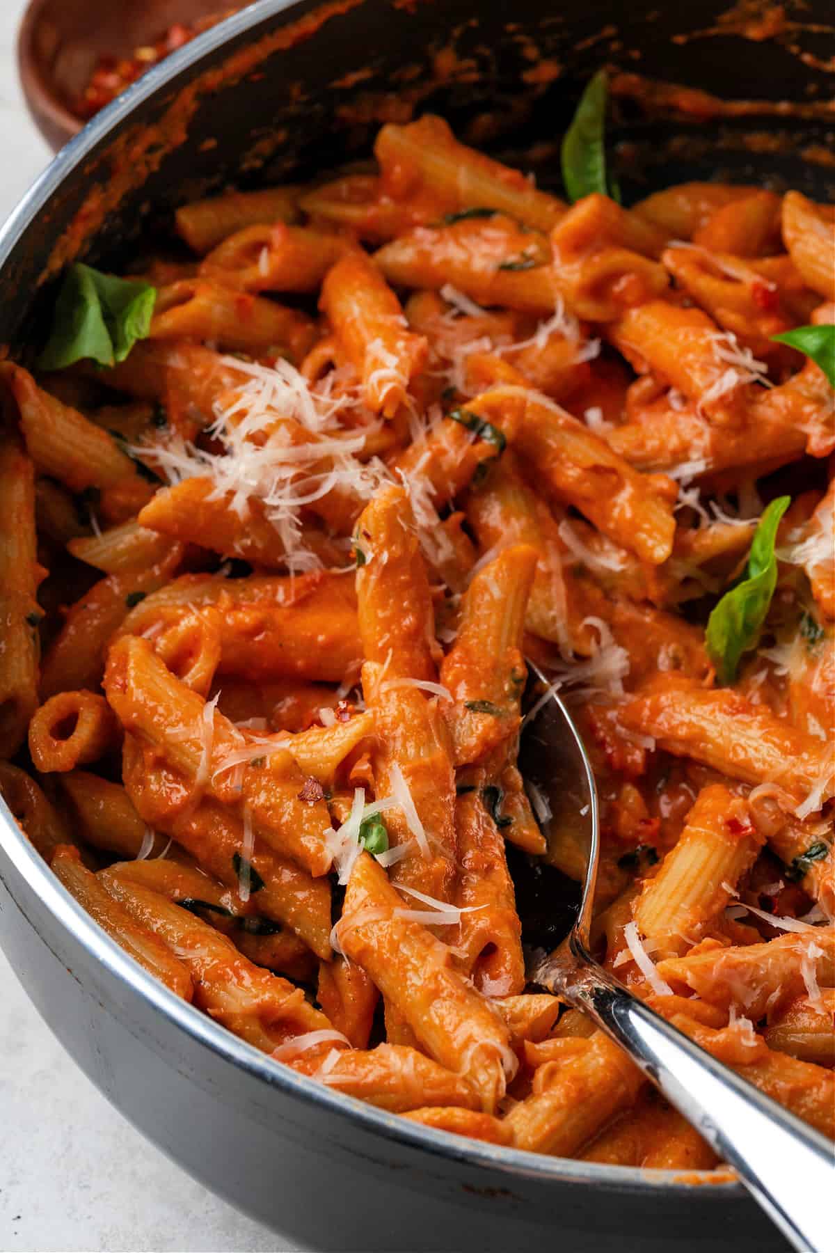 a closeup view of fully cooked one pot creamy tomato pasta in a pan. 