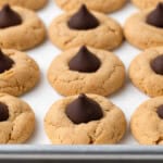 vegan peanut butter blossoms lined up on a baking tray.