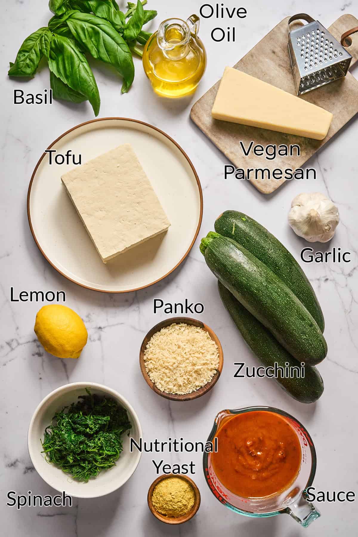 Ingredients to make zucchini rollatini on a marble table top. 