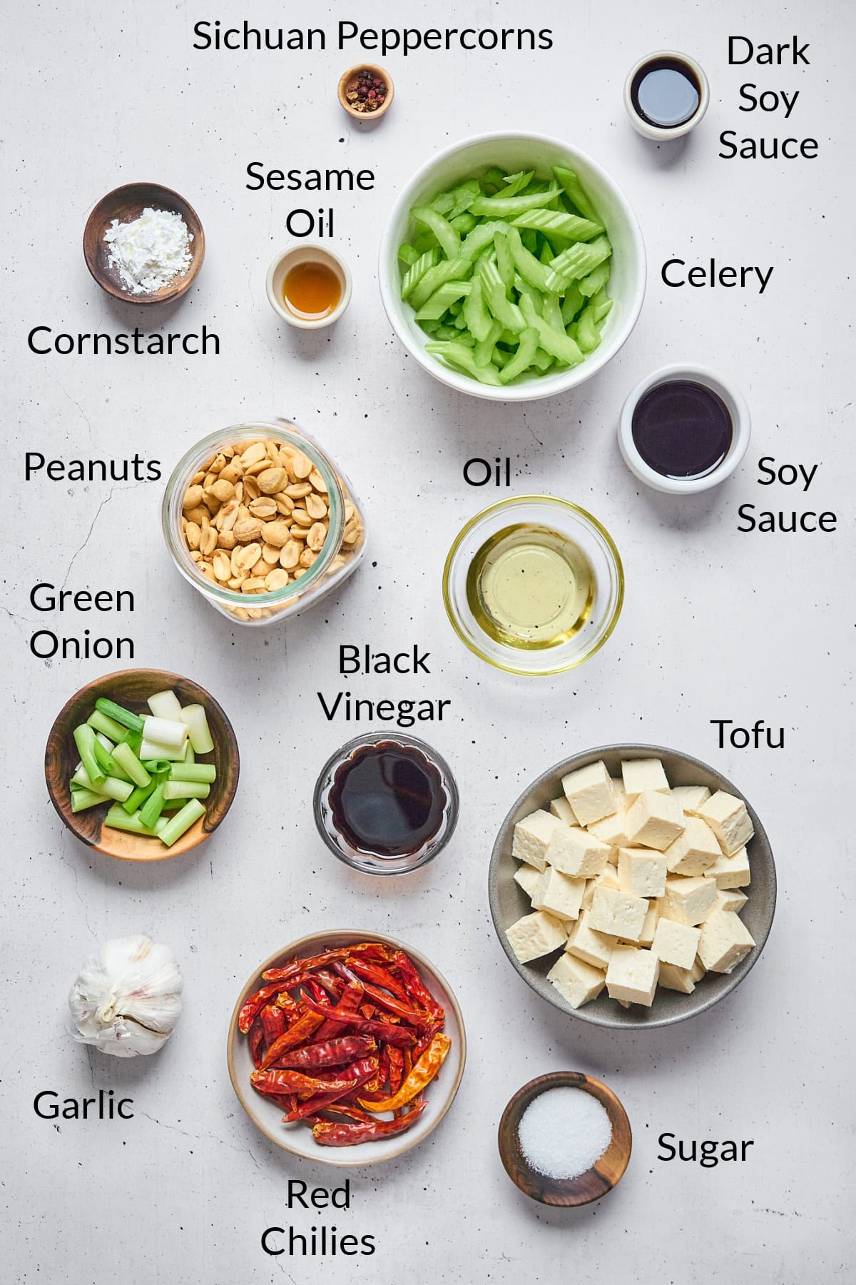 Ingredients to make the tofu dish displayed on a stone table top.