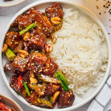 overhead view of kung pao tofu on a plate with napkin on the side.