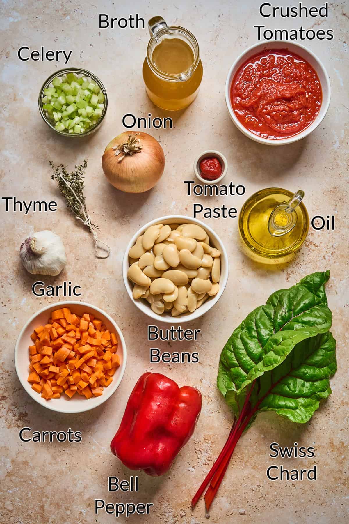 Ingredients to make butter bean stew displayed on a stone table top.