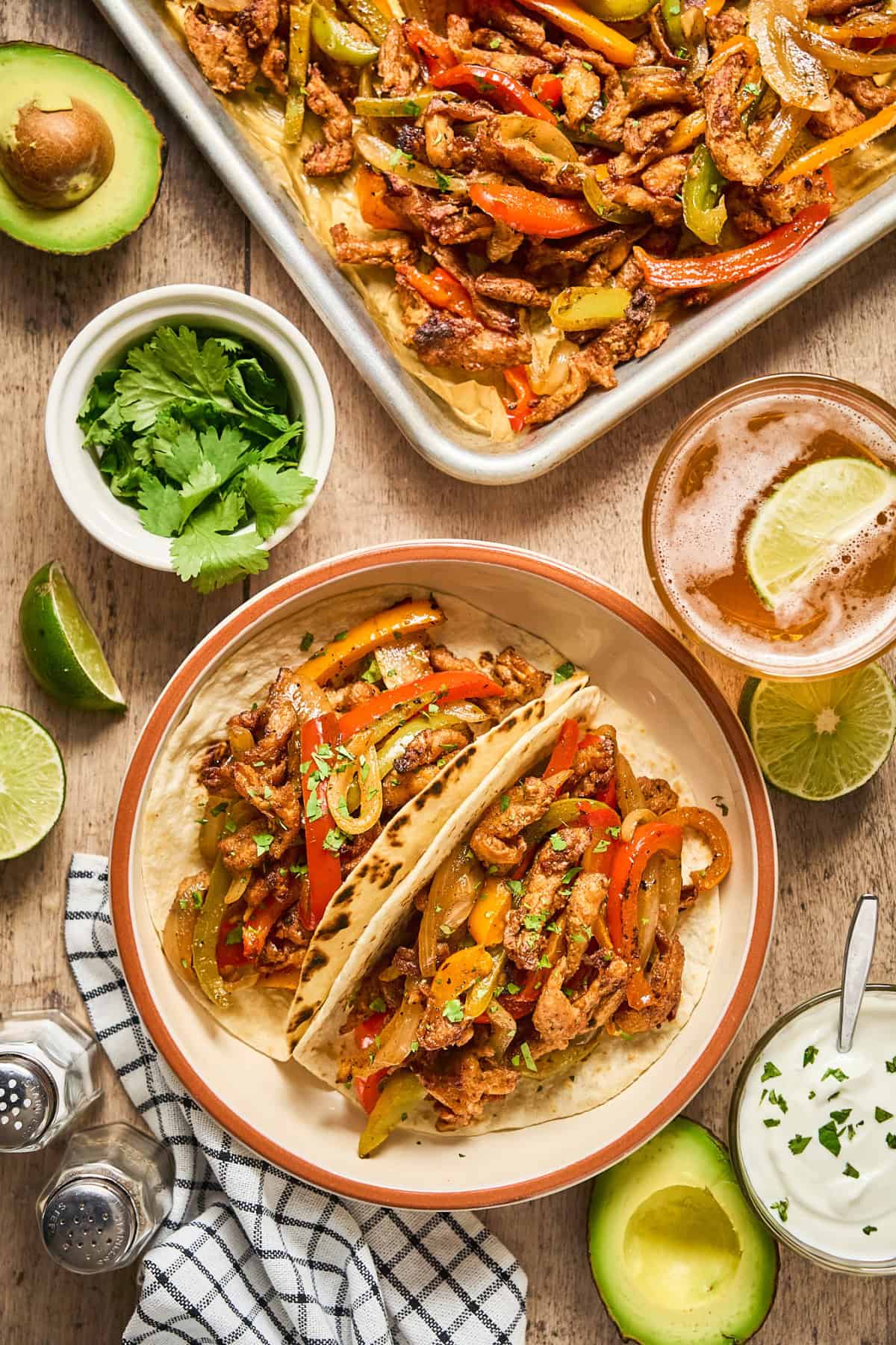 Overhead view of vegan sheet pan fajitas in a bowl and on a pan.
