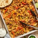 overhead view of sheet pan fajitas with tortilla.