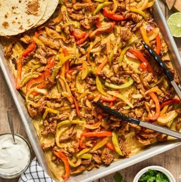 overhead view of sheet pan fajitas with tortilla.