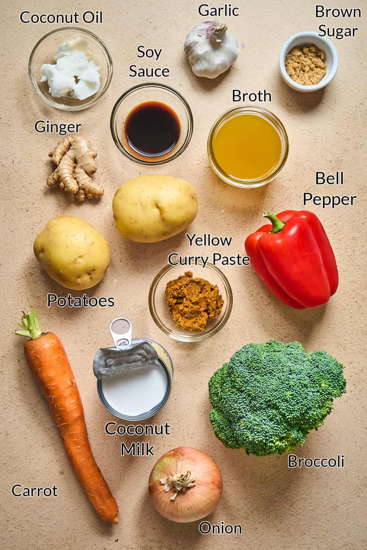 Ingredients to make vegan Thai yellow curry displayed on a stone table top. 
