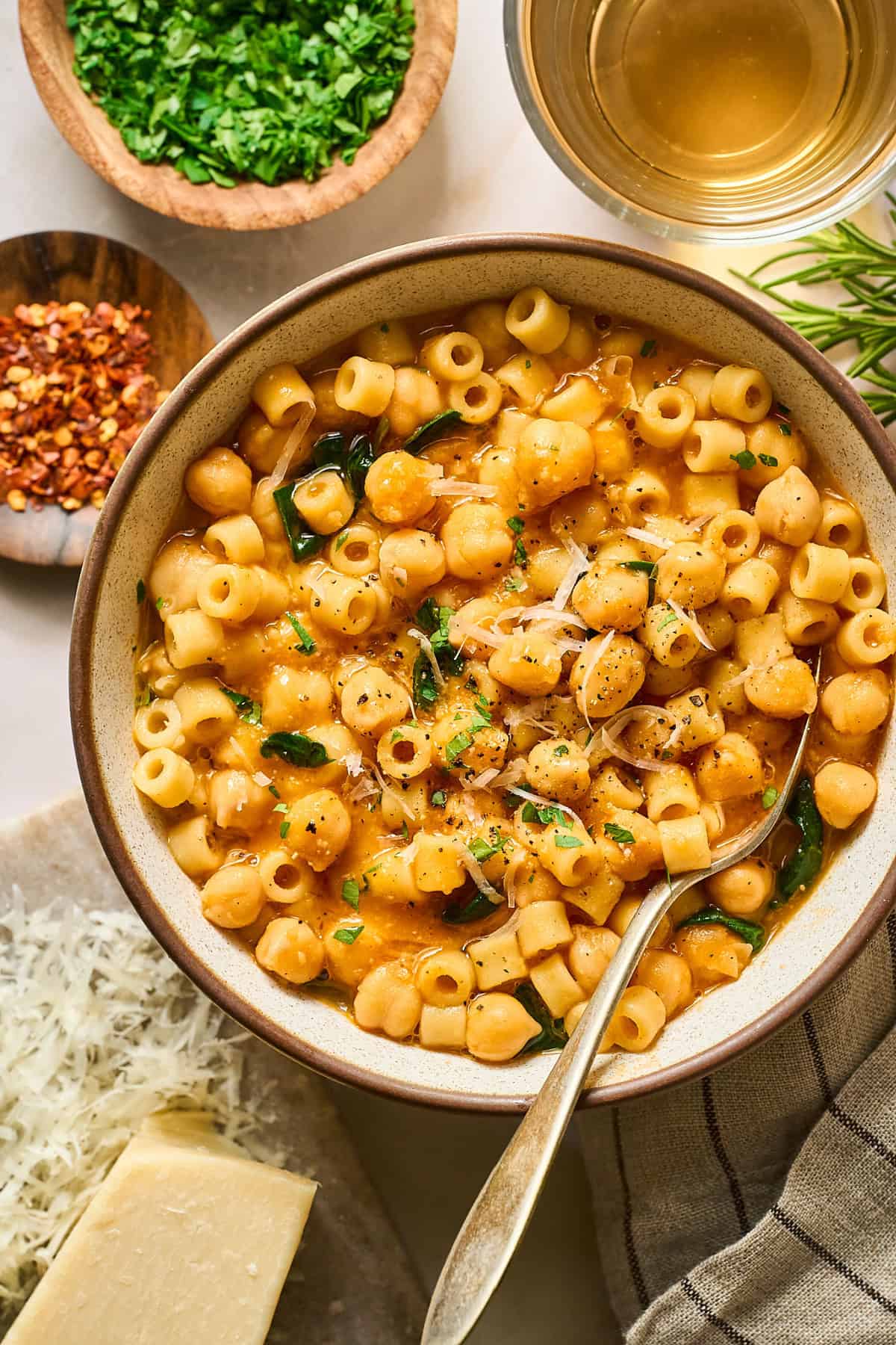 overhead view of a bowl of Pasta e Ceci with a spoon inside.