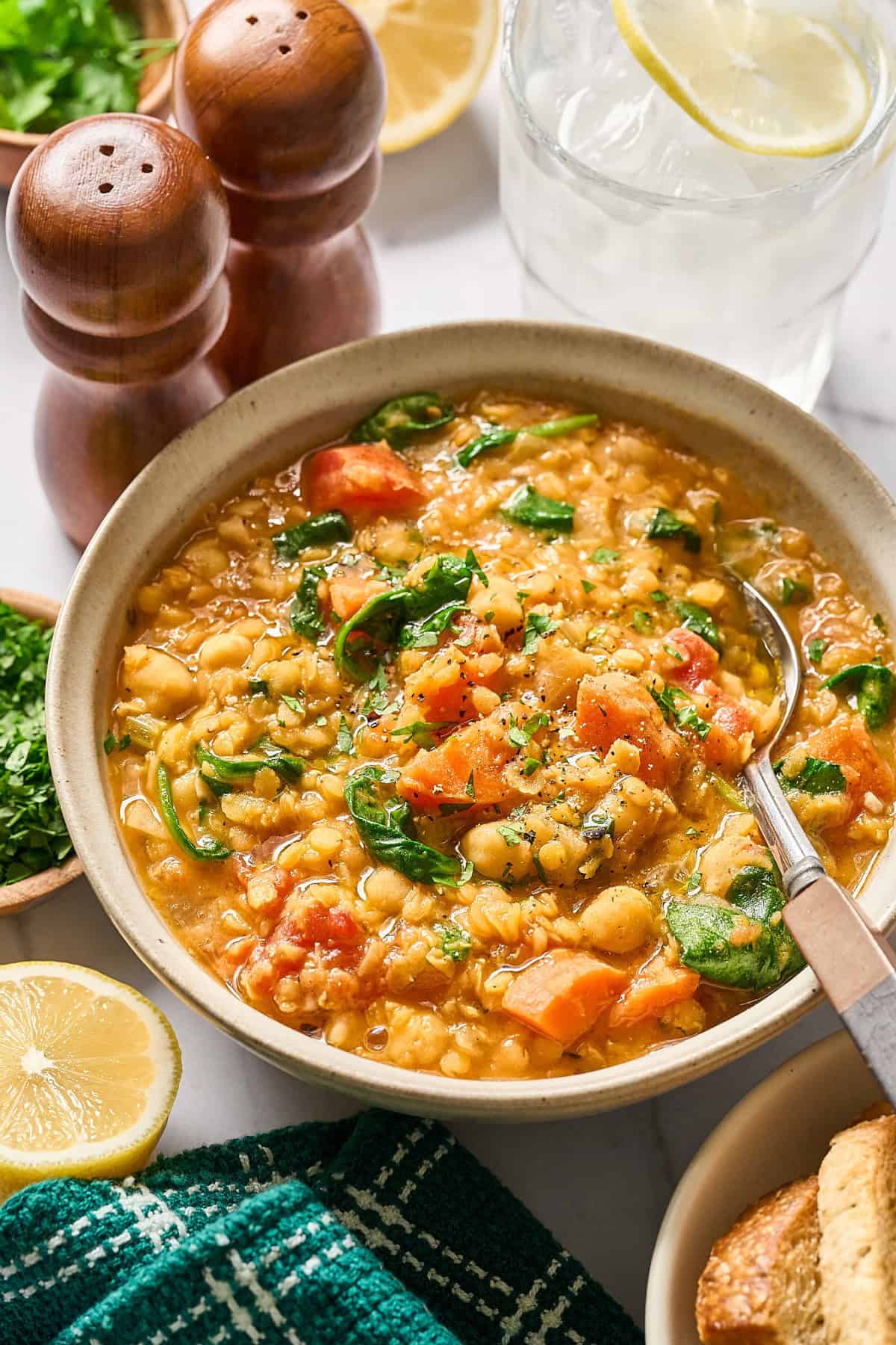 Bowl of red lentil stew with a spoon inside.