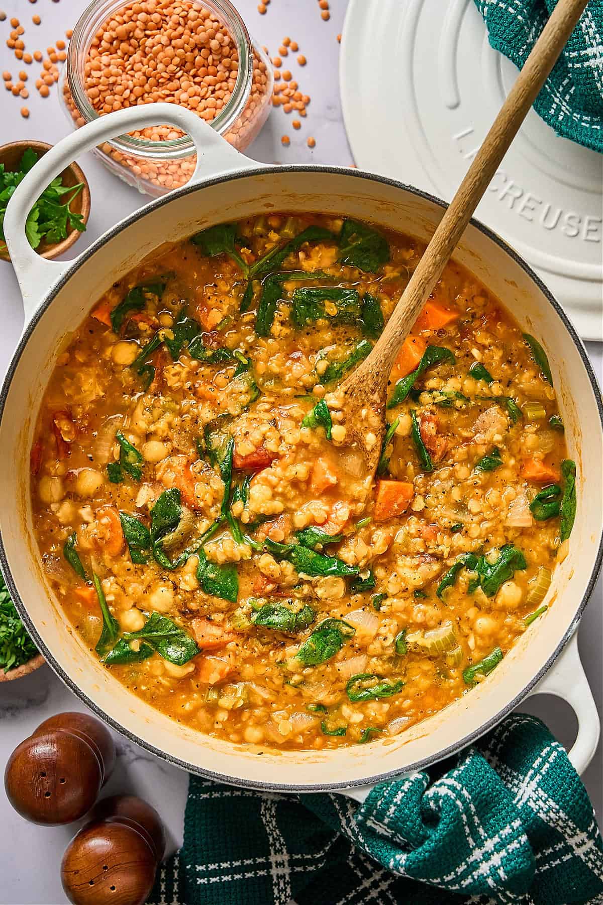 overhead view of red lentil stew in a white pot.