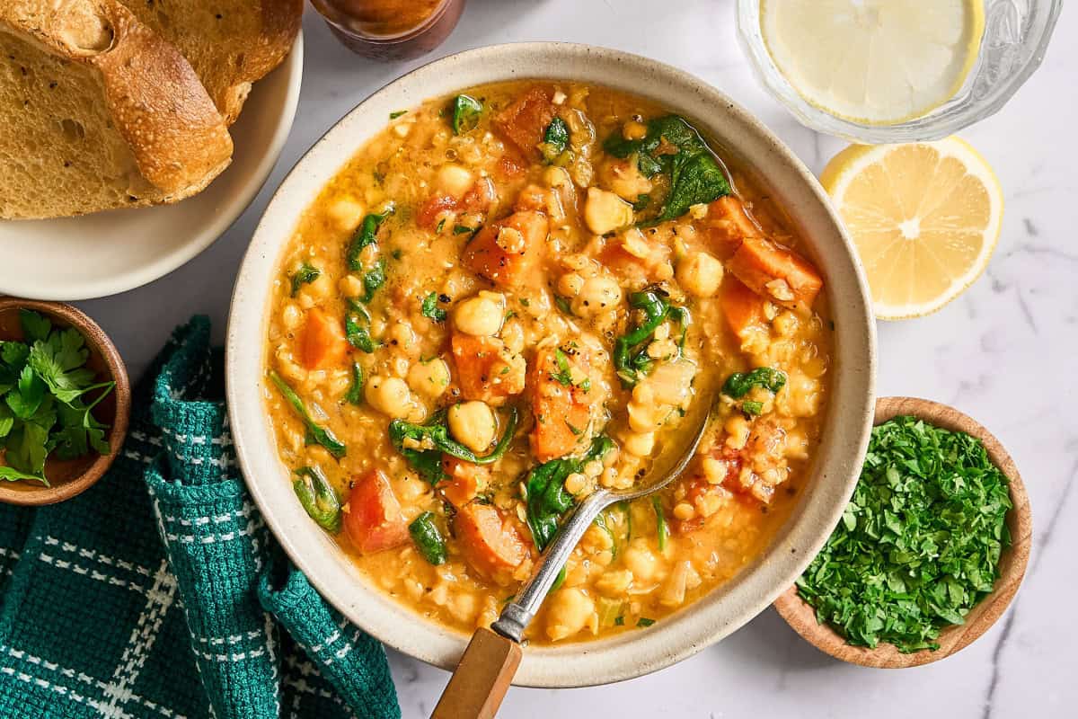 Overhead view of lentil stew with bread on the side. 