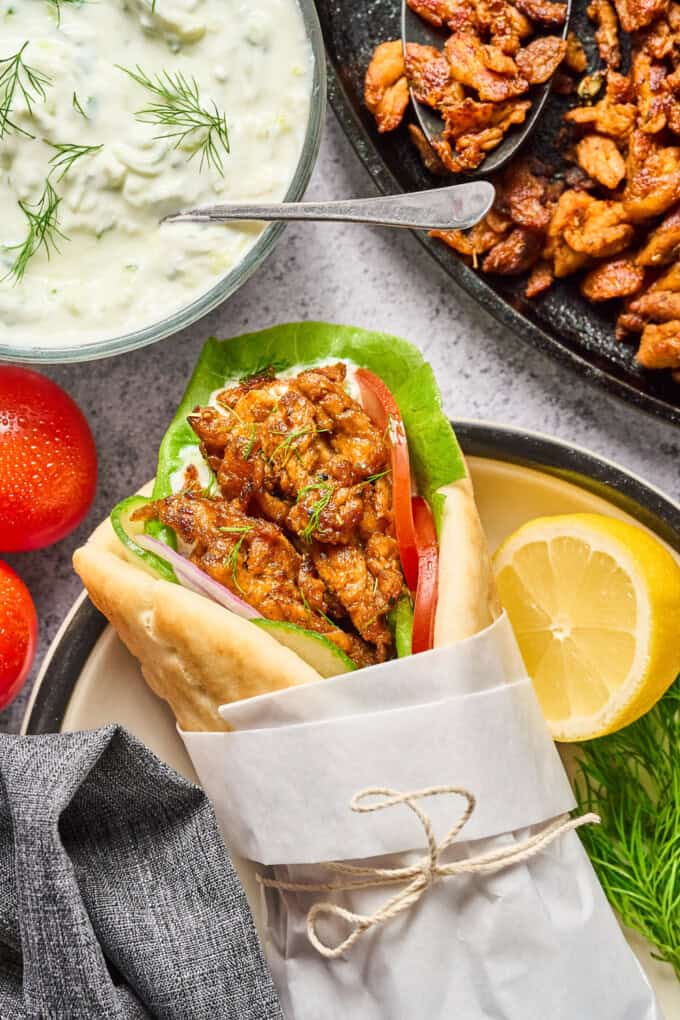 soy curl gyros on a plate with veggies in the side.