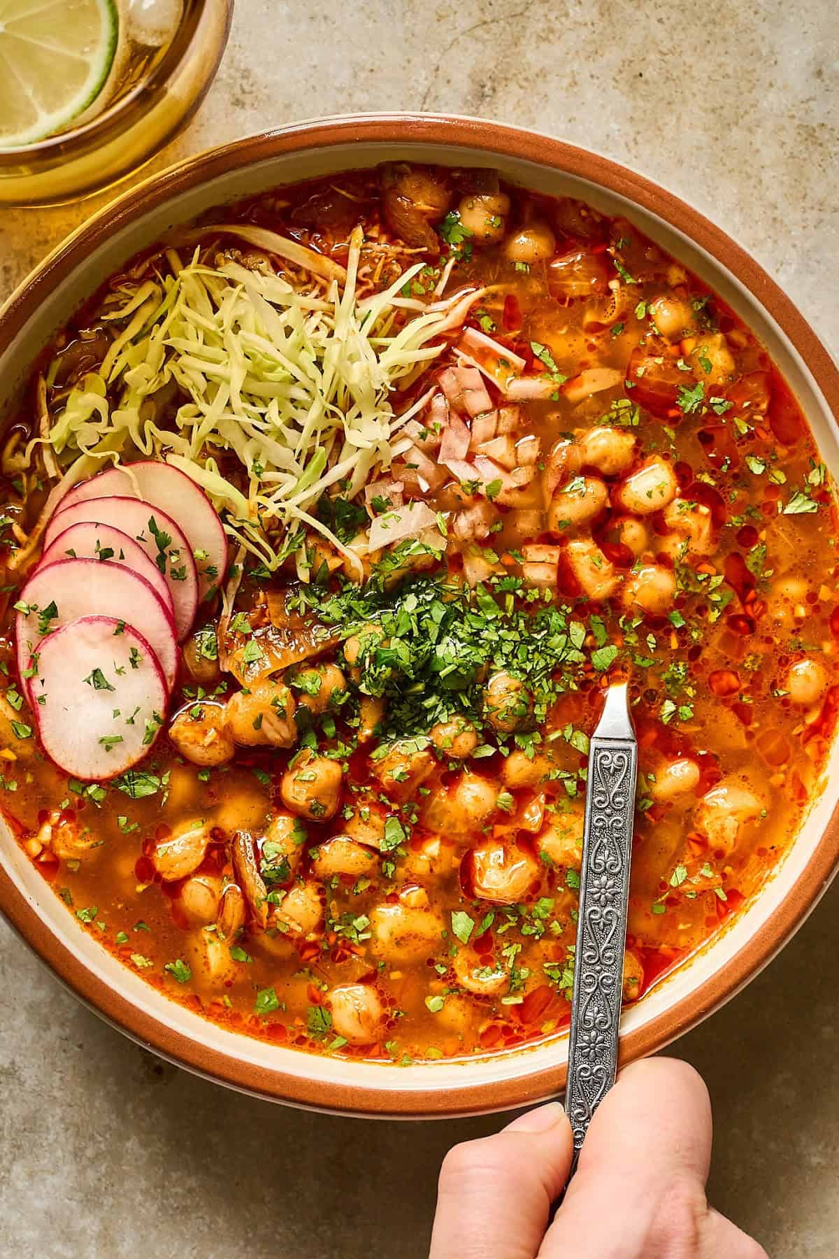 Overhead and close up view of a bowl of vegan posole on a table.