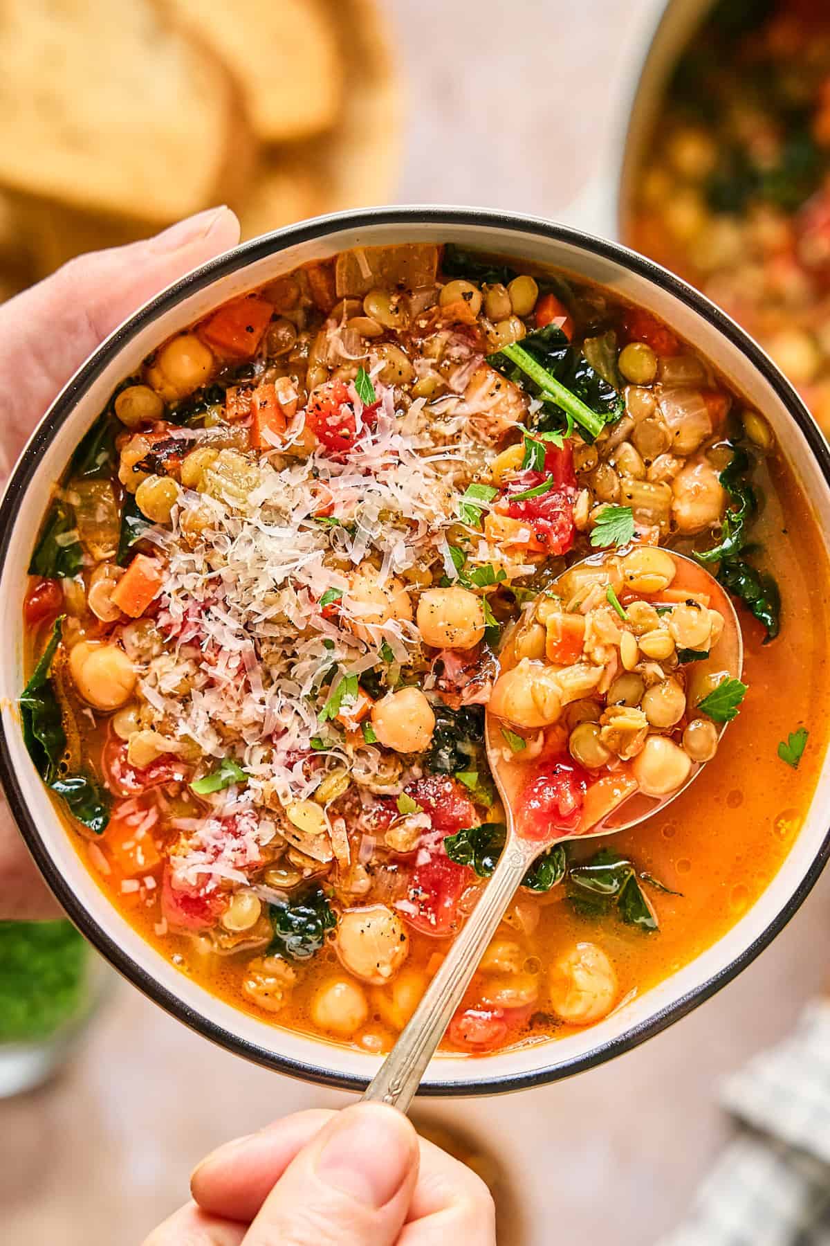 Overhead view of Italian lentil soup in a bowl with a spoon inside.