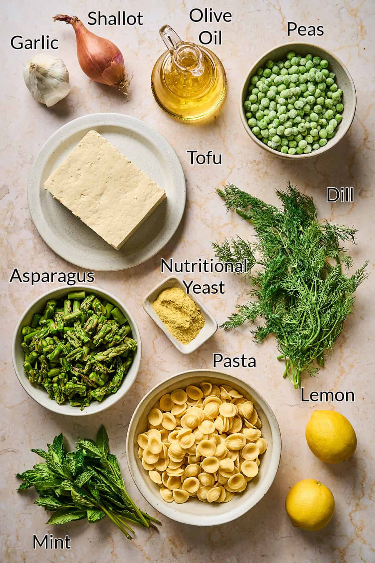 ingredients for spring pasta dish on a stone table top.