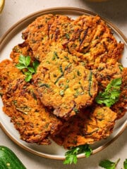 overhead view of red lentil zucchini fritters on a plate.