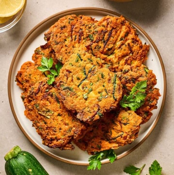overhead view of red lentil zucchini fritters on a plate.