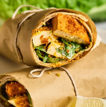 closeup view of a vegan chicken caesar wrap cut in half.